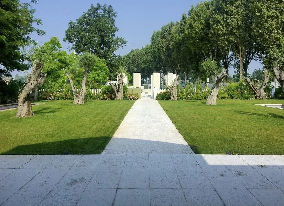 Verde aziendale a Brescia: giardino con prato curato, ulivi e vialetto in pietra